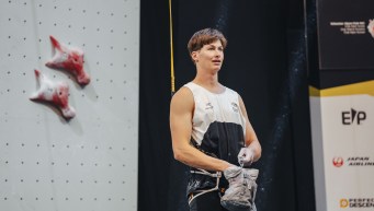 Michael Finn-Henry debout devant le mur d'escalade sportive.