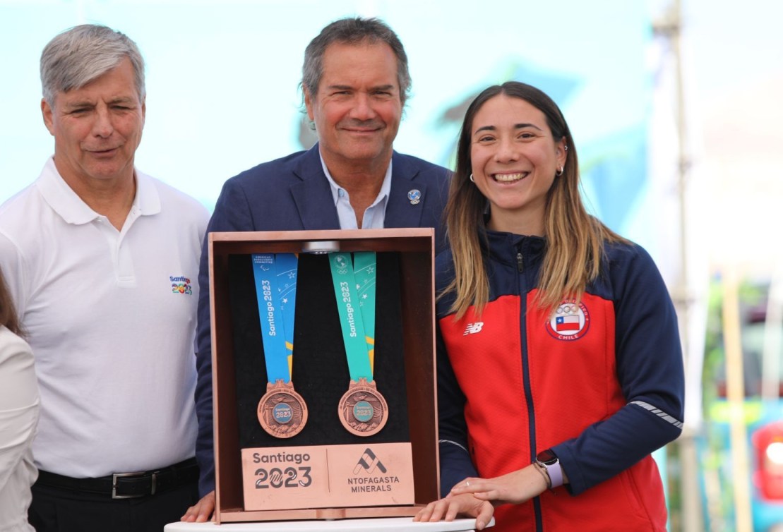 Trois personnes présentent les médailles des Jeux panaméricains et des Jeux parapanaméricains.