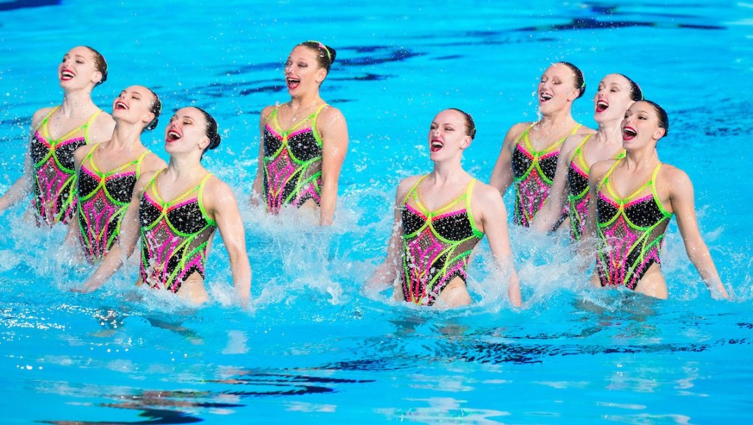 Raphaelle Plante et des nageuses sourient dans l'eau.