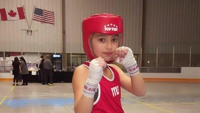 Une enfant avec de l'équipement de boxe.