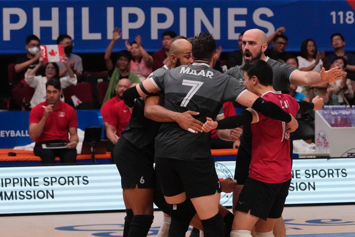 L'équipe masculine canadienne de volleyball célèbre sur le terrain. 