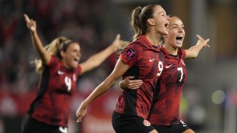 Des joueuses de soccer canadiennes célèbrent sur le terrain.