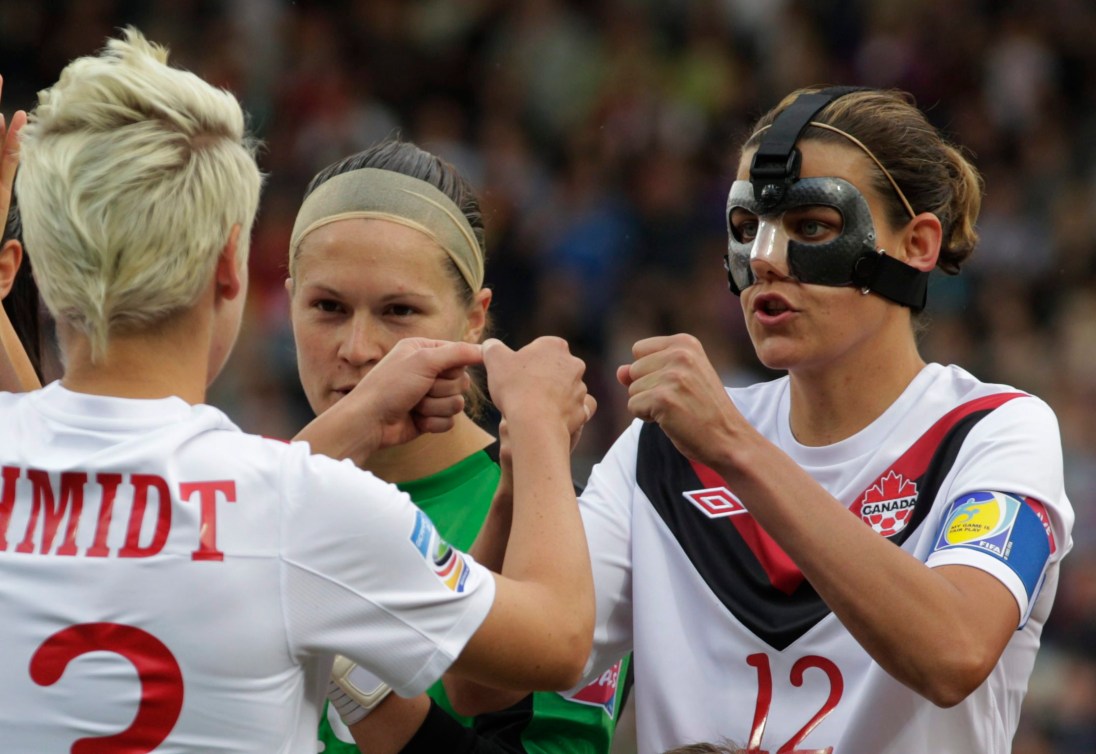 La Canadienne Christine Sinclair, à droite, porte un masque protecteur.