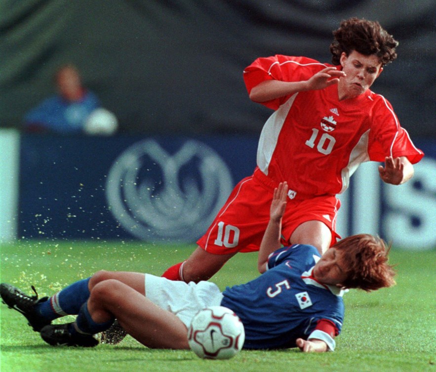 Deux joueuses se disputent le ballon sur le terrain de soccer.