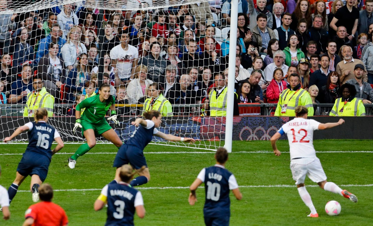 La gardienne de but des États-Unis, Hope Solo, au centre à gauche, ne parvient pas à arrêter un but de Christine Sinclair.