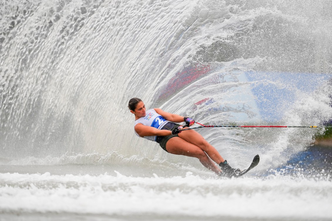 Paige Rini, submergée par une vague, tient la poignée à deux mains.