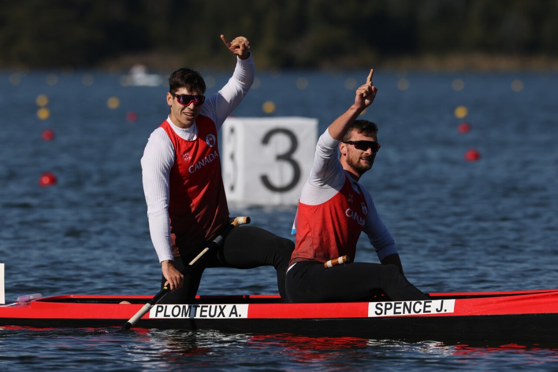 Alix Plomteux et Craig Spence, signalant le chiffre un avant leurs mains, dans leur canot.