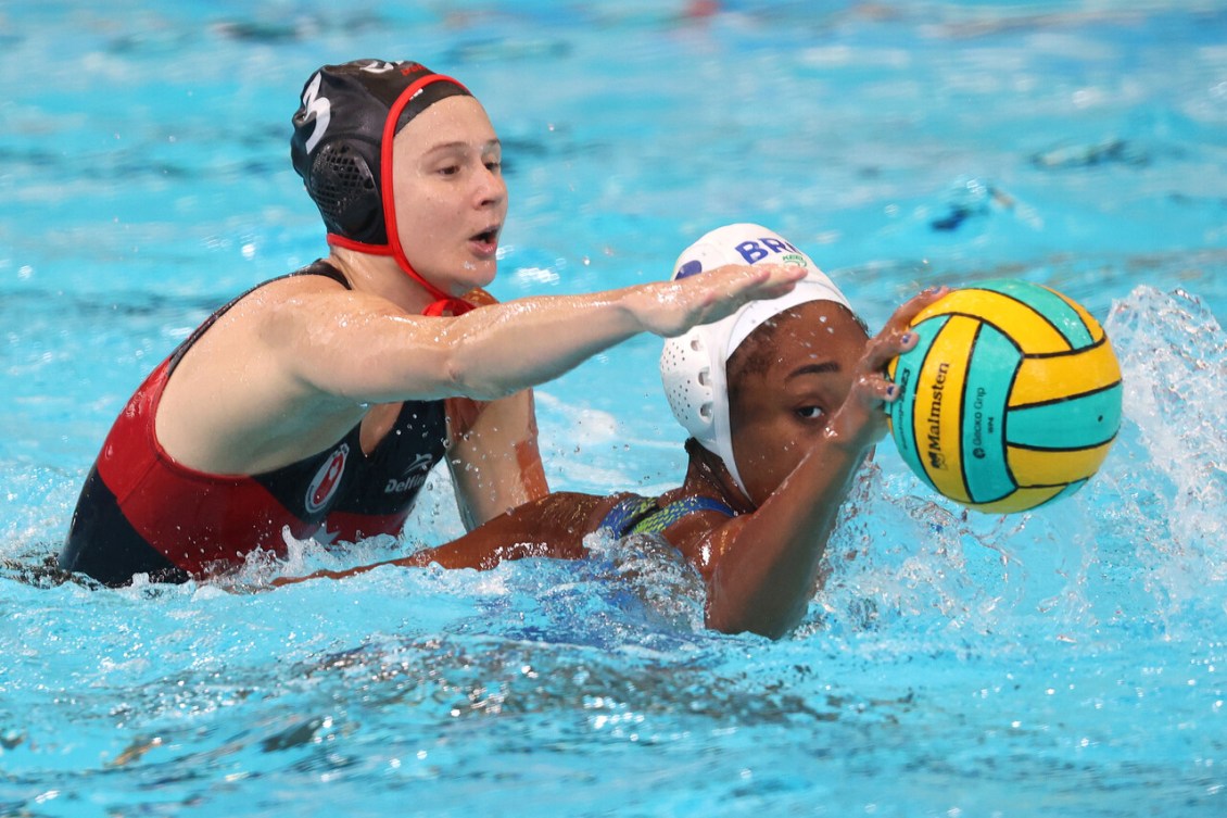 Axelle Crevier tente d'enlever le ballon à son adversaire, dans la piscine.