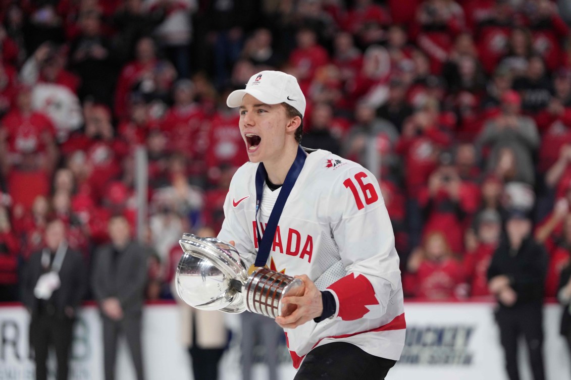 Connor Bedard tient un trophée. 