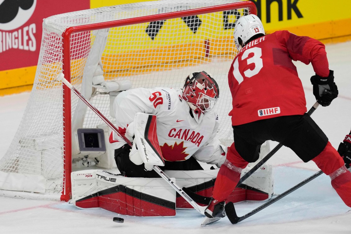 Nico Hischier tente de glisser la rondelle sous Jordan Binnington