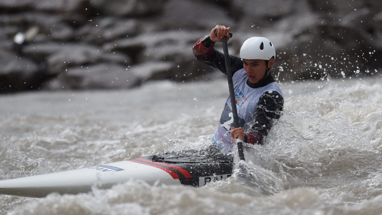 Un athlète de canoë slalom participe à une épreuve. 