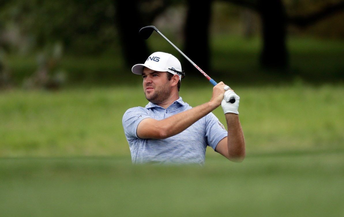 Corey Conners sur le terrain de golf regarde sa balle au loin.