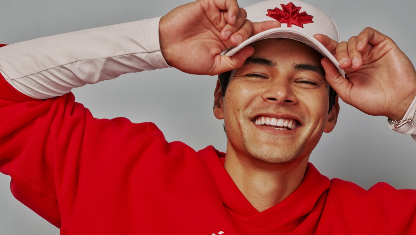 Un fan porte une casquette blanche avec une feuille d'érable rouge sur le devant.