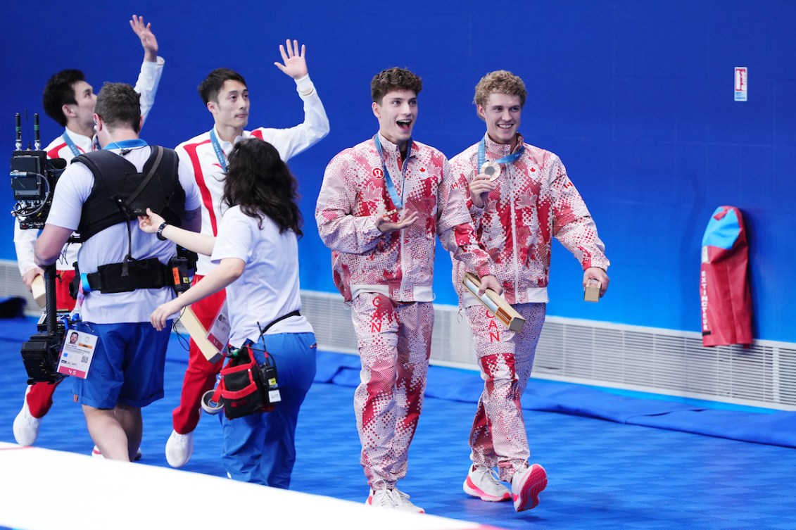 Rylan Wiens (à droite) et Nathan Zsombor-Murray marchent avec leur médaille autour du cou. 