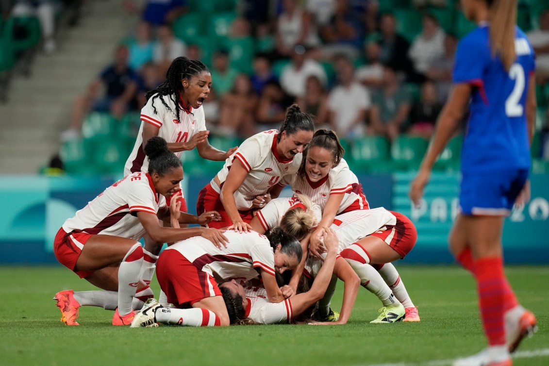 Les joueuses canadiennes célèbrent sur le terrain.