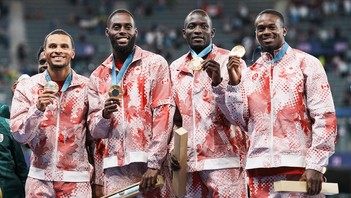 Les médaillés d'or d'Équipe Canada au relais masculin 4 x 100 m d'athlétisme posent avec leur médaille.