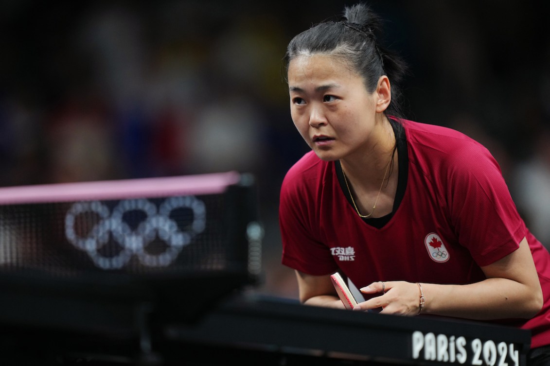 Mo Zhang pendant un match de tennis de table.