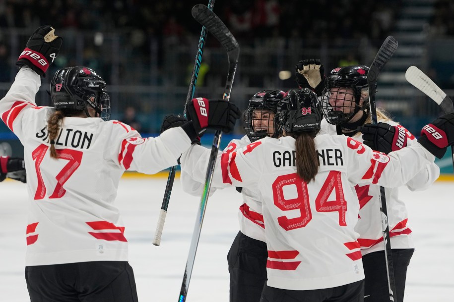 Plusieurs coéquipières d'Équipe Canada célèbrent un but ensemble.