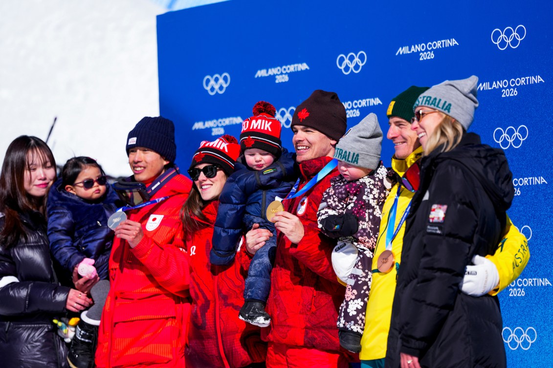 Mikaël Kingsbury en compagnie des médaillés d'argent et de bronze avec leur enfant et conjointe.