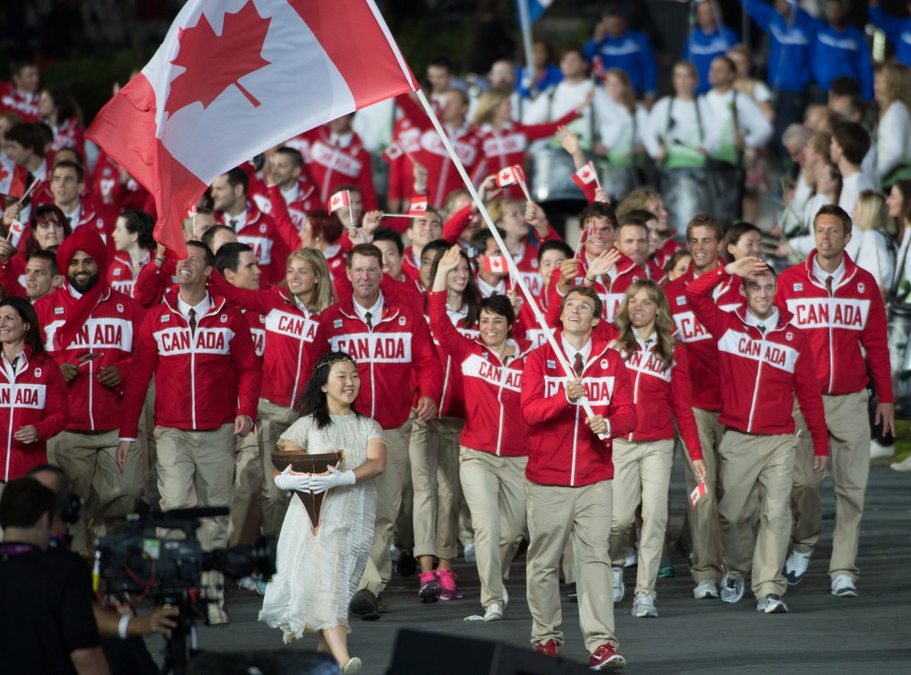 Two-time triathlon medallist Simon Whitfield bears the flag for team Canada during the opening ceremonies to the 2012 London Olympics, on July 27, 2012. THE CANADIAN PRESS/HO, COC - Jason Ransom