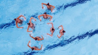 Overhead shot of eight artistic swimmers doing arm movements