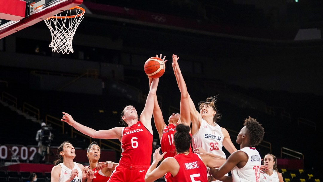 Canadian and Serbian plays battle for the basketball in a women's game