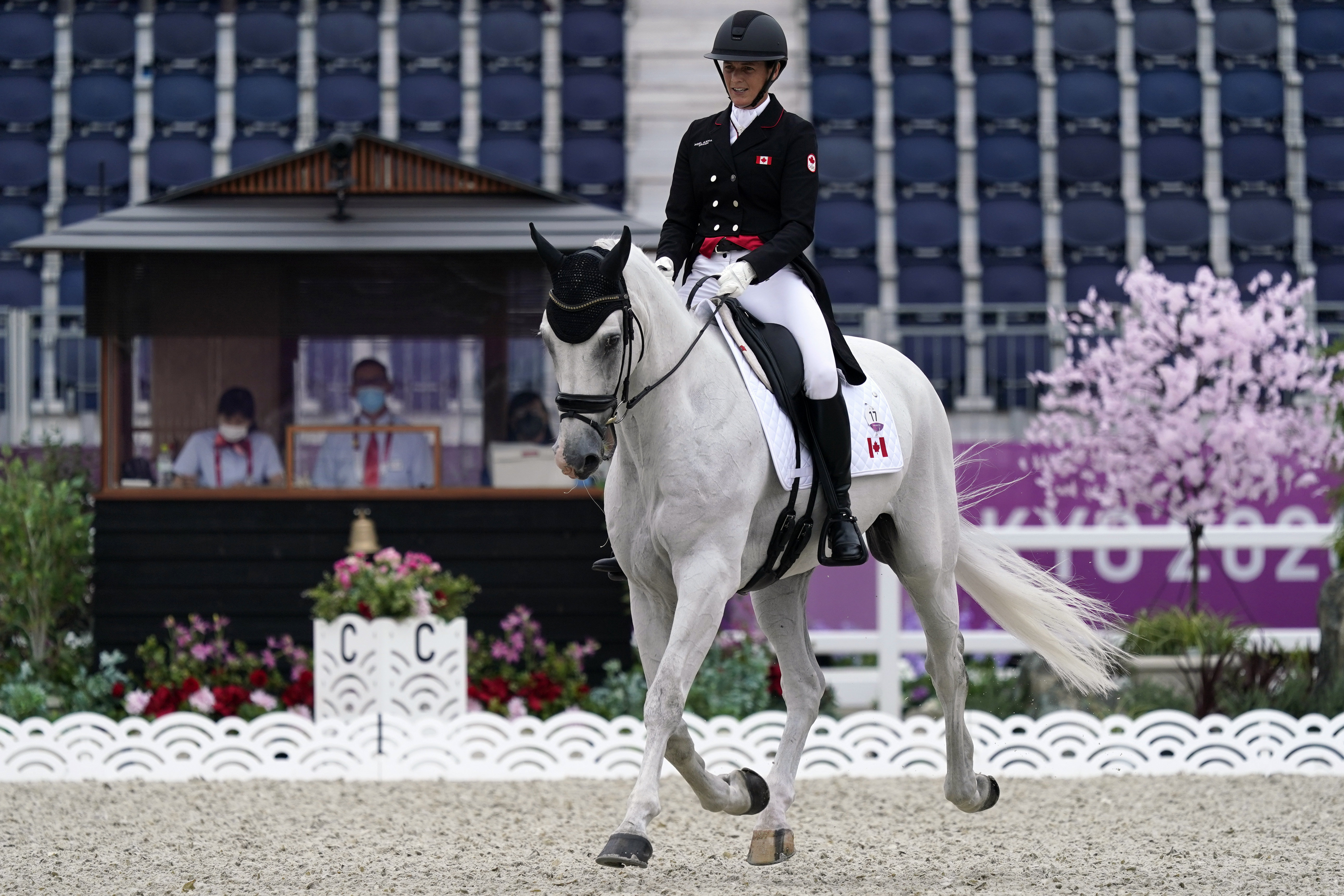 Colleen Loach rides a white horse in dressage competition 