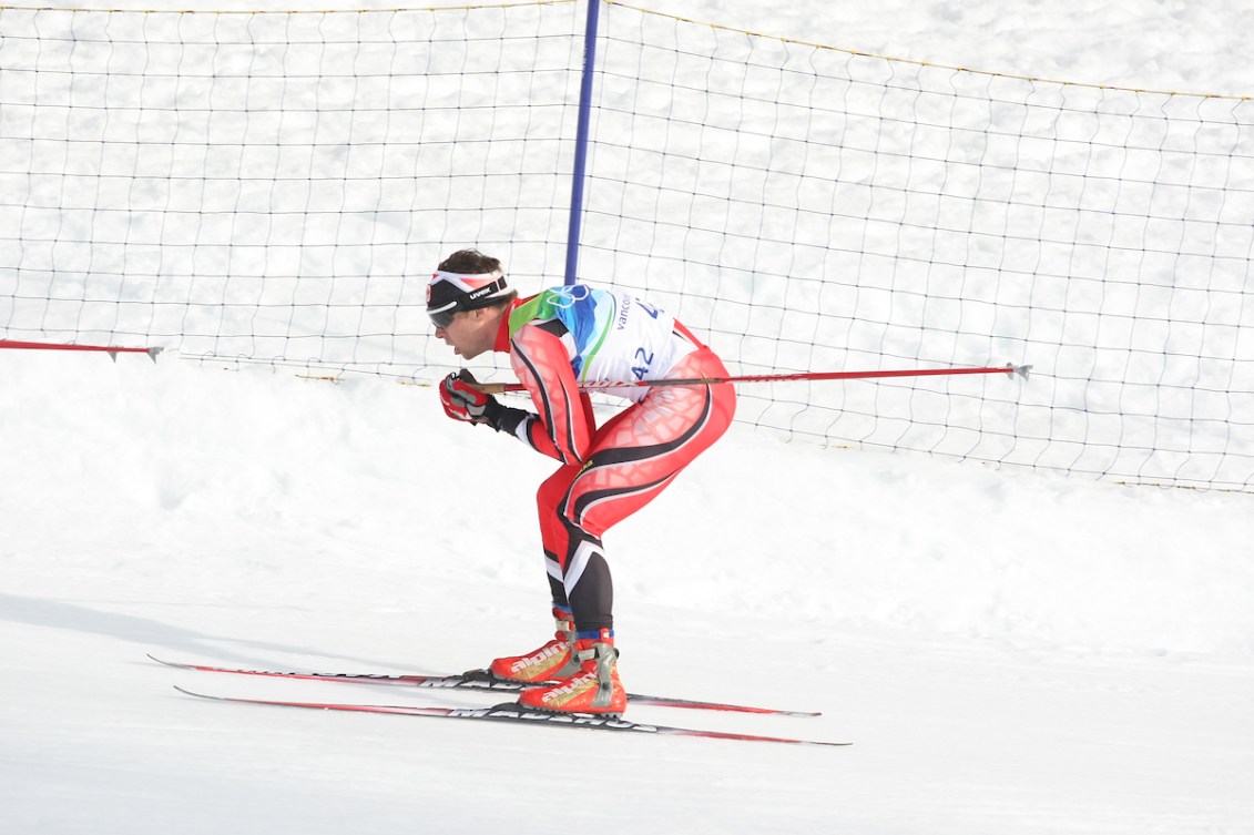 Cross country skier in red suit glides on a course 