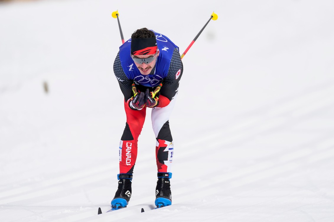 Antoine Cyr holds his poles behind him as he glides on cross country skis 