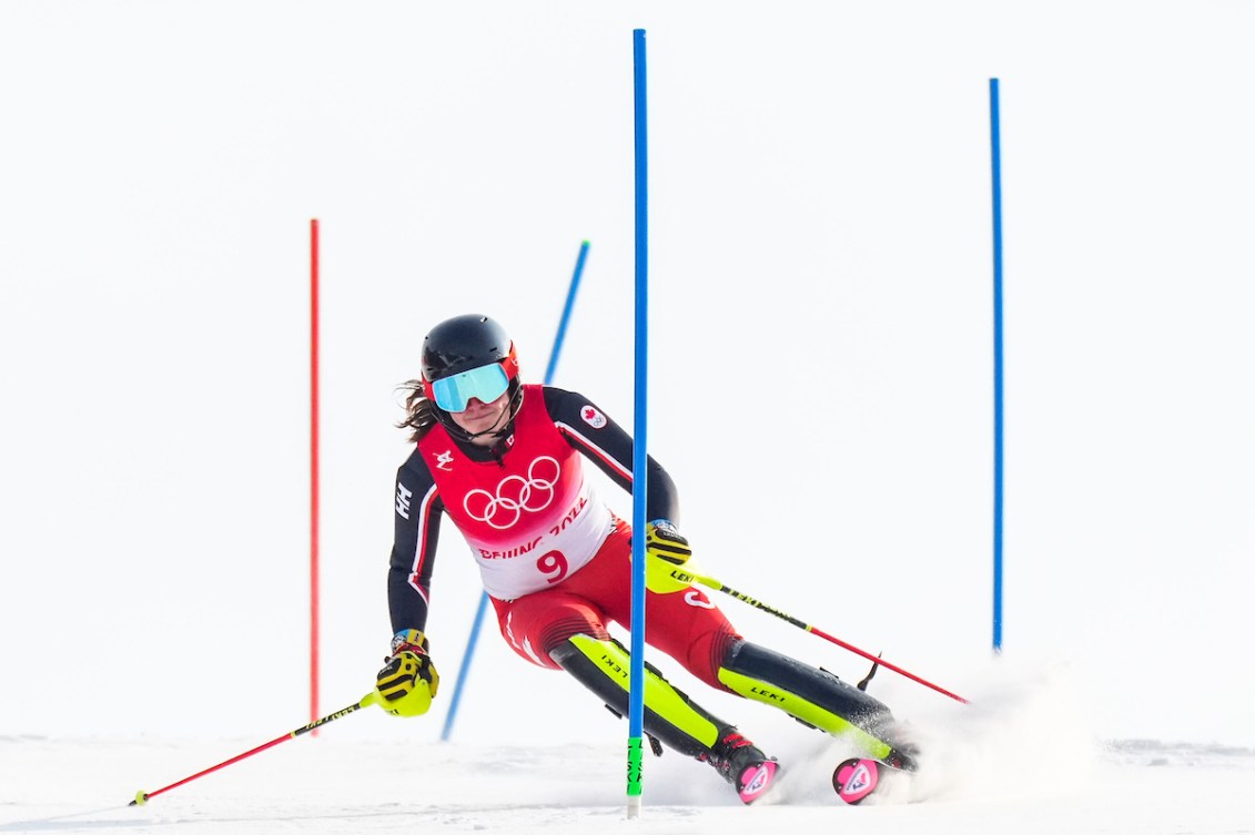 A female alpine skier goes past red and blue pole gates 