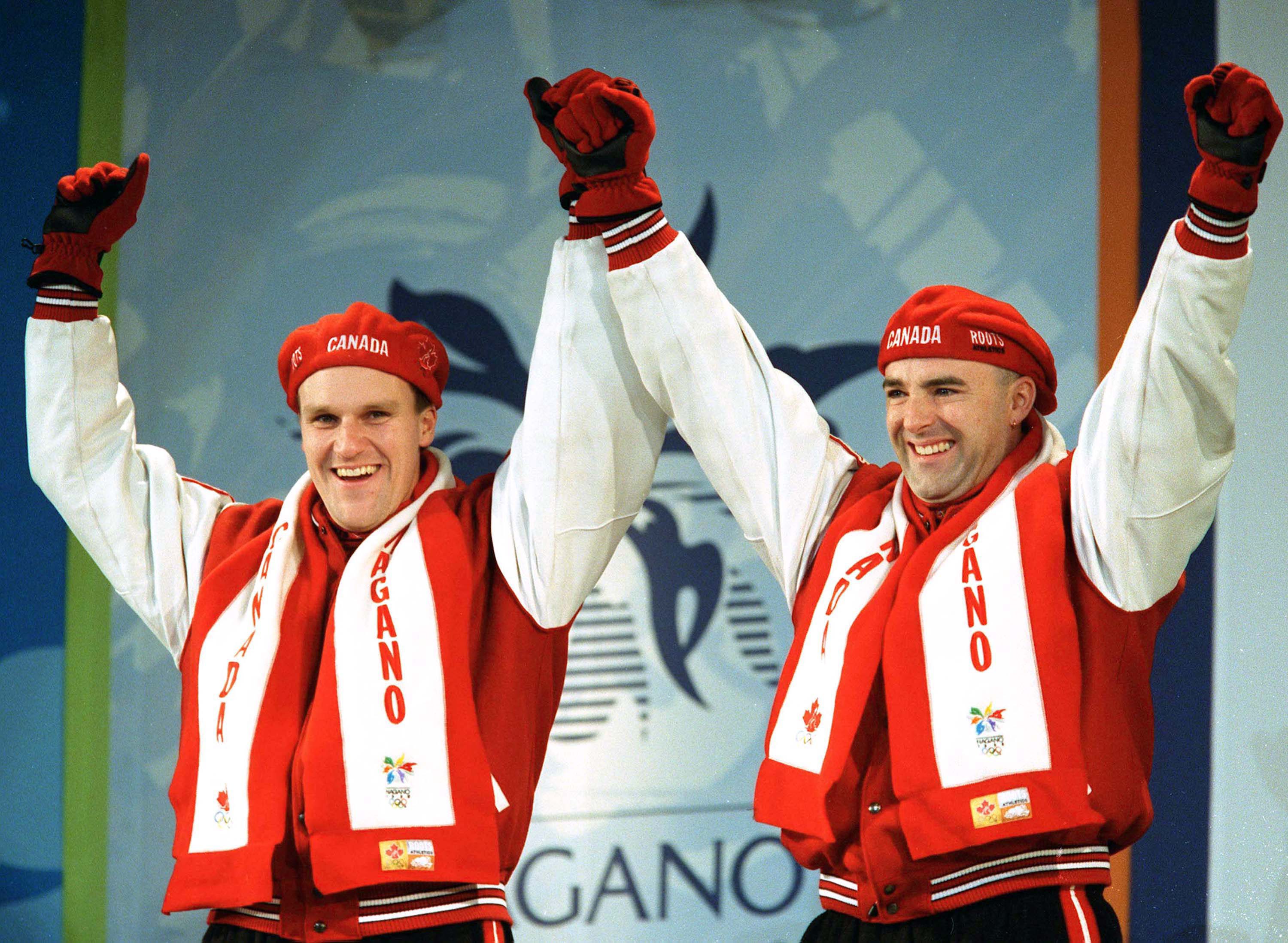 Canada's Pierre Lueders (left) and Dave MacEachern celebrate their gold medal win in the two-man bobsleigh event at the Nagano 1998 Olympic Winter Games. (CP PHOTO/COC/F. Scott Grant)