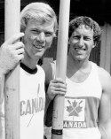 Two rowers stand with their oars