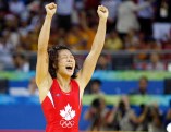 Canada's Carol Huynh from Hazelton, B.C. celebatres her gold medal victory over Chiharu Icho from Japan in the women's freestyle 48kg wrestling final at the Beijing 2008 Summer Olympics in Beijing, Saturday, August 16, 2008. THE CANADIAN PRESS/Paul Chiasson