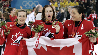 Campbell holds the Canadian flag and her medal with two teammates