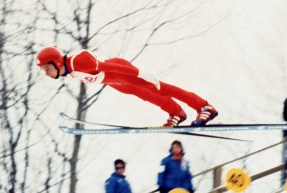 Steve Collins flies through the air while competing in ski jumping