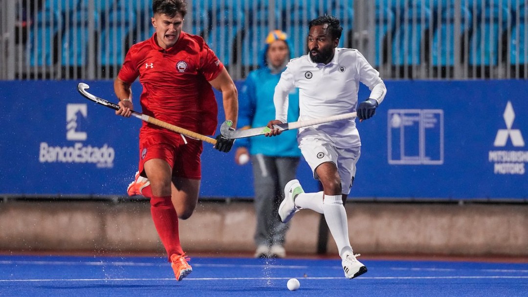 Two field hockey players chase down the ball