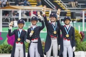 Four equestrian athletes holding up figurines
