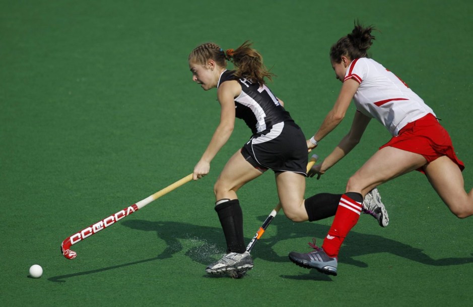 Canada's Hannah Haughn, left, is caught on the foot by Martyna Gabar of Poland during their field hockey Olympic qualifier in New Delhi, India,