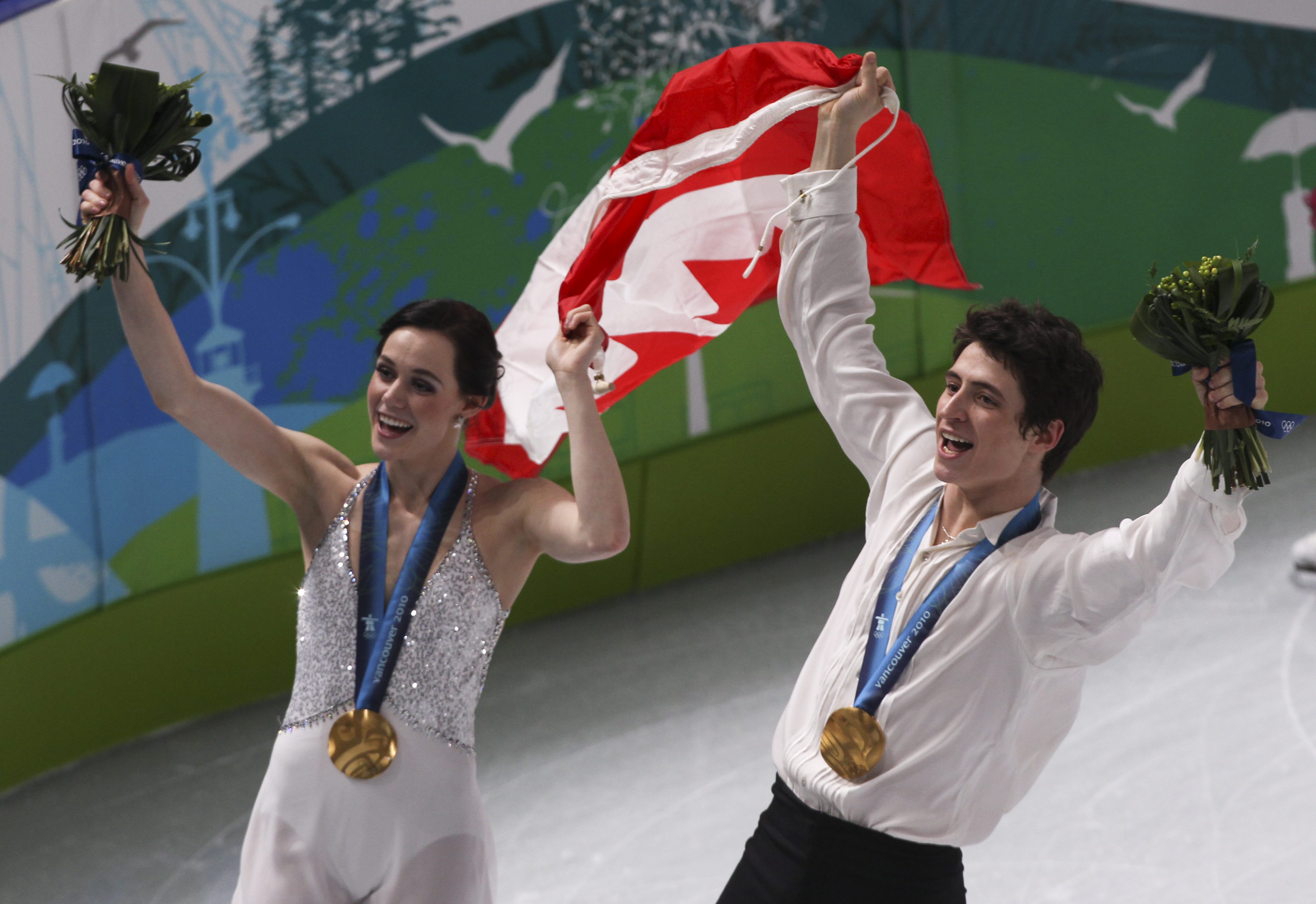 Tessa Virtue of London, Ont. and Scott Moir of Ilderton, Ont. do a victory lap with their gold medals in ice dance at the Pacific Coliseum at the Olympic Winter Games in Vancouver, B.C, Monday, Feb. 22, 2010. (CP PHOTO)2010(HO-COC-Mike Ridewood)