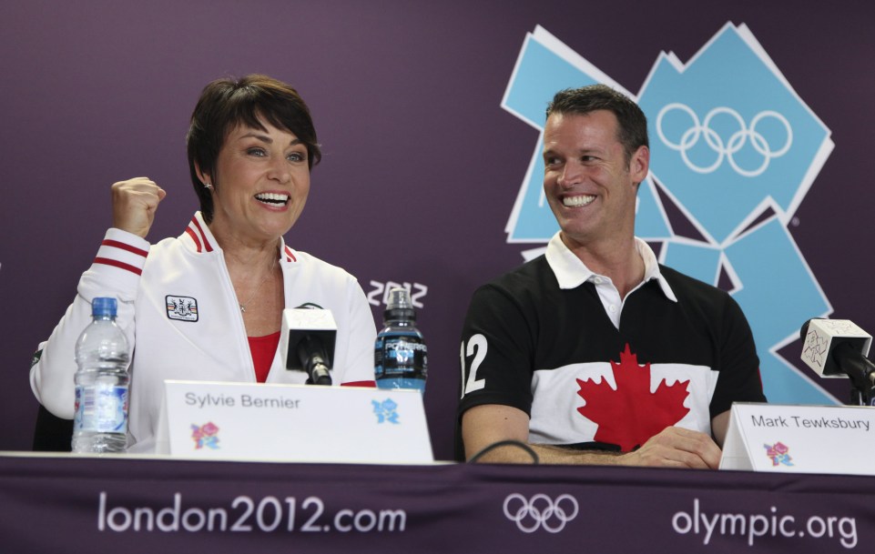 Sylvie Bernier and Mark Tewksbury sit at a press conference table