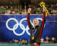 Marc Gagnon with arms raised on podium