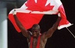 Canada's Daniel Igali waves the Canadian flag after winning the gold medal in wrestling at the 2000 Sydney Olympic Games. (CP Photo/ COC)