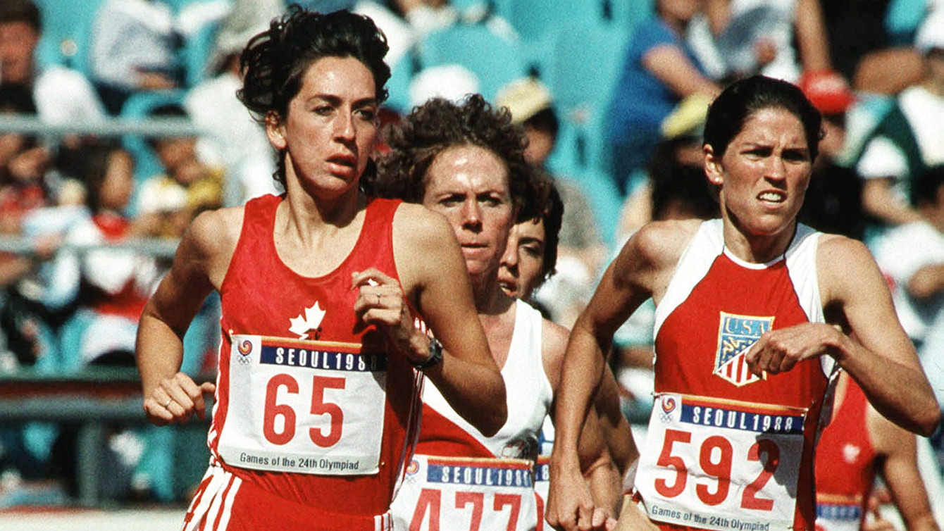 An older photograph depicts two women runners in red singlets