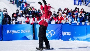 Mark McMorris raises his arms in celebration at the bottom of the course