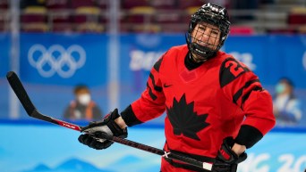 Natalie Spooner smiles through her face shield on the ice