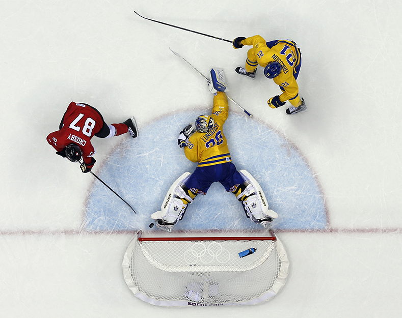 Canada forward Sidney Crosby scores a goal on Sweden goaltender Henrik Lundqvist during the second period of the men's gold medal ice hockey game at the 2014 Winter Olympics, Sunday, Feb. 23, 2014, in Sochi, Russia. (AP Photo/David J. Phillip )