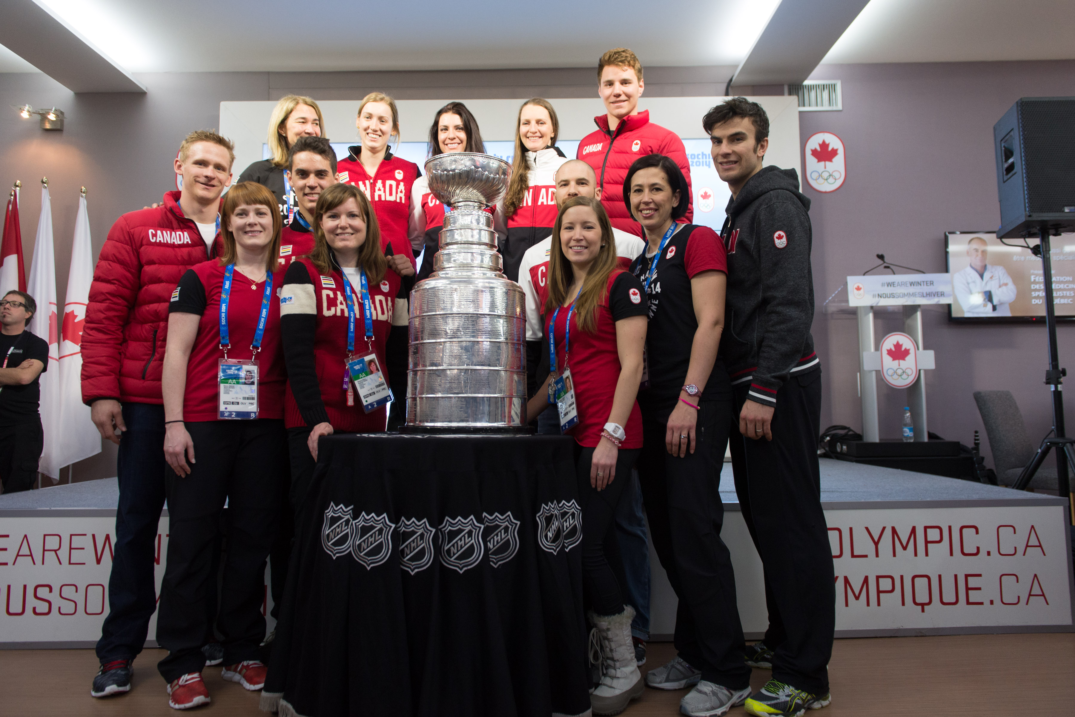 People posing for a picture with the Stanley Cup