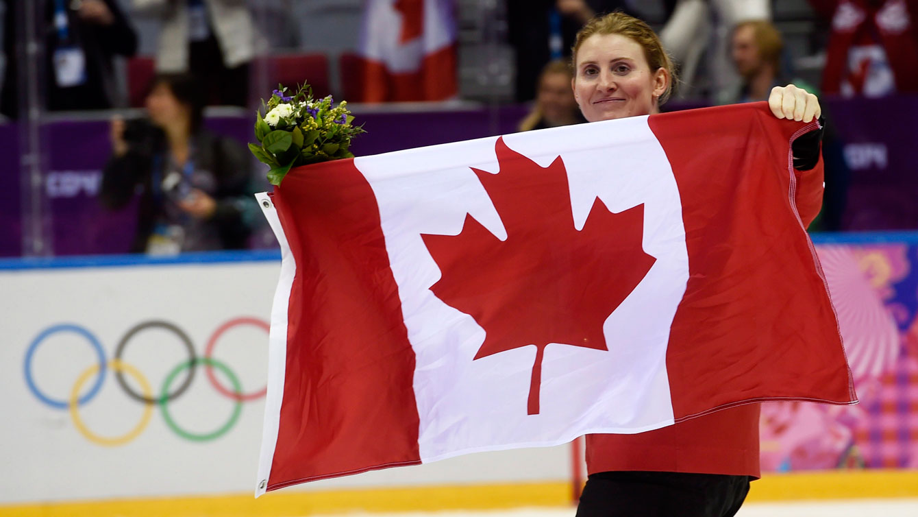 Hayley Wickenheiser skates with the Canadian flag after the gold medal game in Sochi. 
