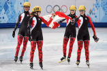 Marie-Ève Drolet, Jessica Hewitt, Valérie Maltais and Marianne St-Gelais holding the Canadian flag in celebration of their 3000m relay Olympic silver medal win at Iceberg Skating Palace in Sochi, Russia. Marie-Ève Drolet (L), Valérie Maltais and Marianne St-Gelais (R) celebrate after Chaina's disqualification announcement earning Canada silver in the women's 3000m relay in Sochi. (Photo: CP)