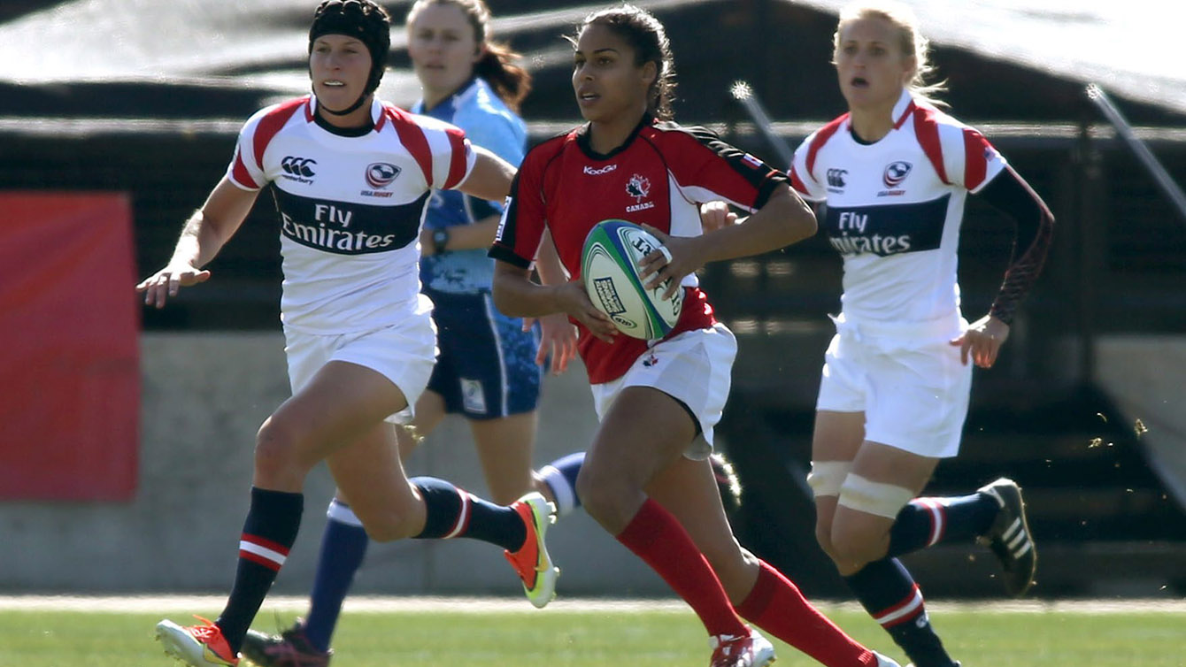 Canada's Magali Harvey runs the ball past United States players in their women's Sevens World Series rugby game at Kennesaw State University, Saturday, Feb. 15, 2014, in Kennesaw, Ga. (AP Photo/Jason Getz)